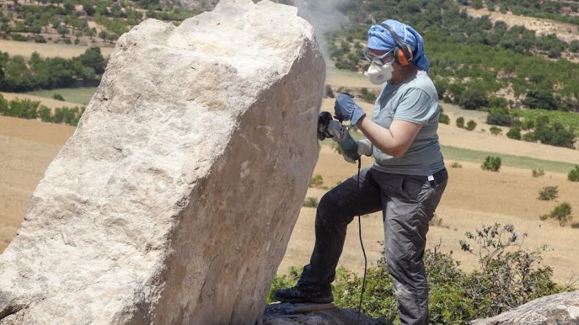 Imatge d'arxiu d'una artista treballant una pedra al festival de Maldà