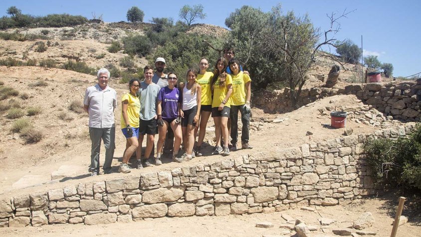 Alguns dels joves mostrant el mur de pedra seca i les escales que han construït