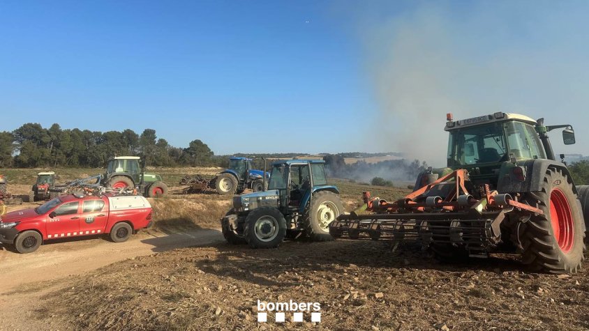 Pagesos amb tractors treballant ahir a la zona per frenar l'incendi