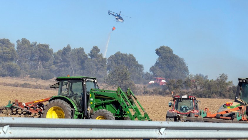 Tractors llaurant per frenar l'incendi.