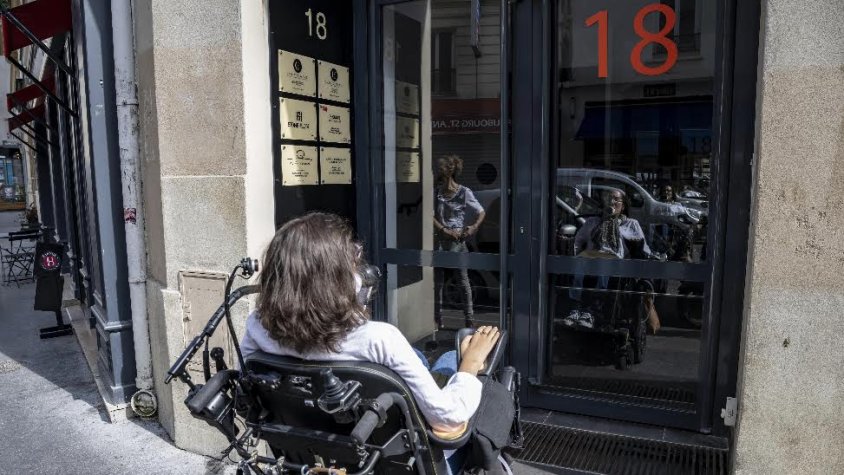 Marta Morera, amb la seua cadira de rodes davant de la porta de l’apartament