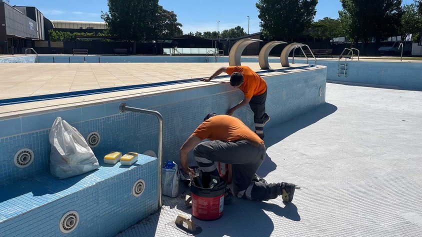 Operaris dels Serveis Municipals realitzant tasques de manteniment a les piscines