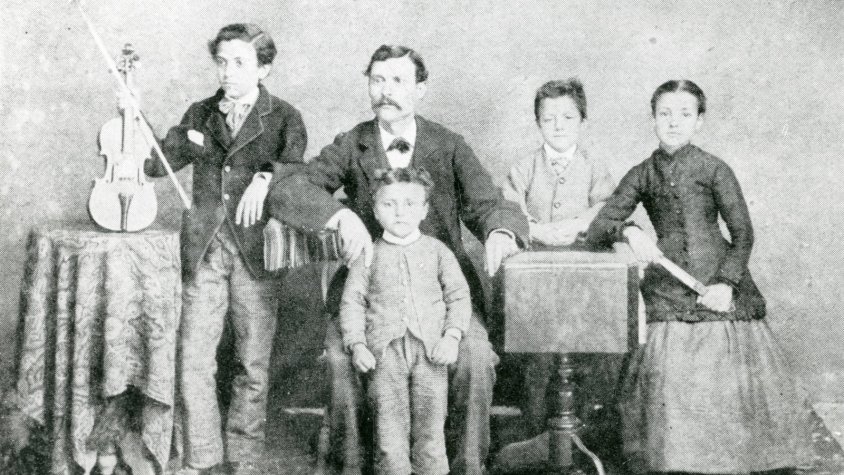 Imatge de la família de Josep Güell. El futur Mestre amb el violí a les mans acompanyat dels seus germans i el seu pare, aprox. 1890