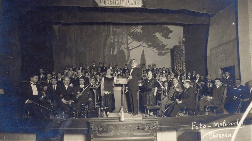 El Mestre Güell dirigint l'Orfeó Nova Tàrrega, les orquestres Pau Casals i Simfònica de Barcelona, i la soprano Mercè Plantada, al Teatre Ateneu