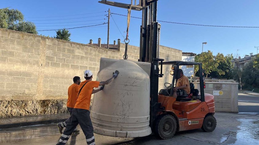Operaris de la brigada efectuant l'actuació de neteja de les parts inferiors dels contenidors
