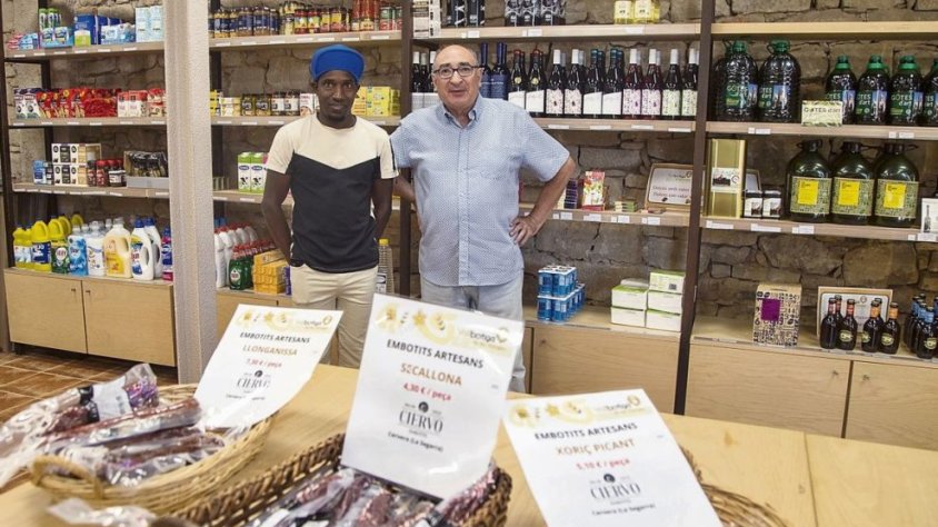 L’alcalde i el responsable de la botiga amb alguns dels molts productes que ofereixen