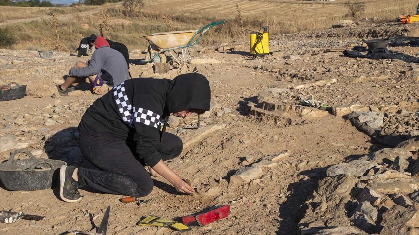 Una estudiant excavant una urna funerària sense túmul