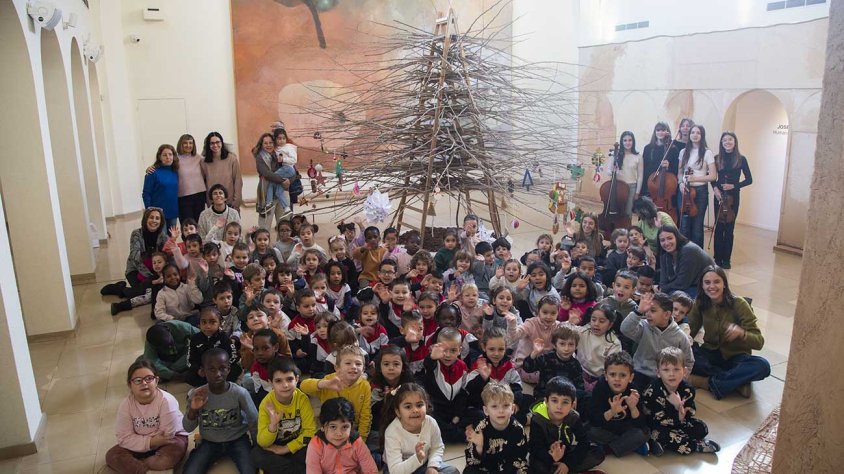 Foto de família dels participants en l'activitat 'Nadal a l'Espai' amb l'arbre ja ornamentat