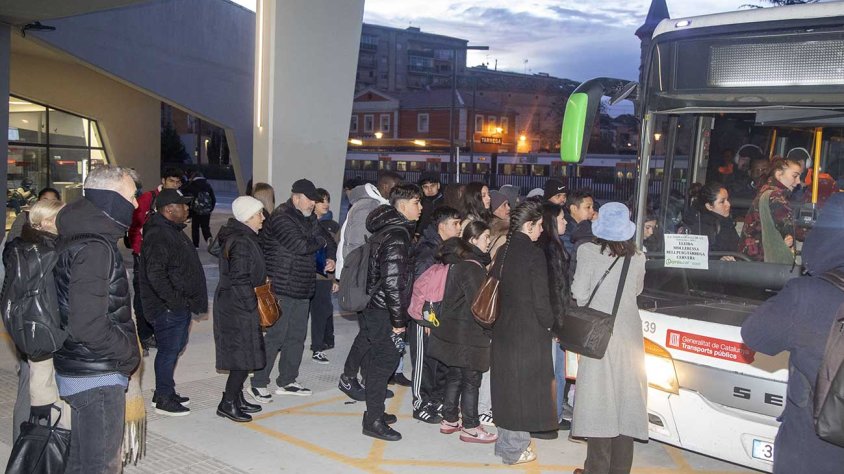 Cues a Tàrrega per agafar un bus amb un tren parat al fons per la caiguda del centre de control d'Adif