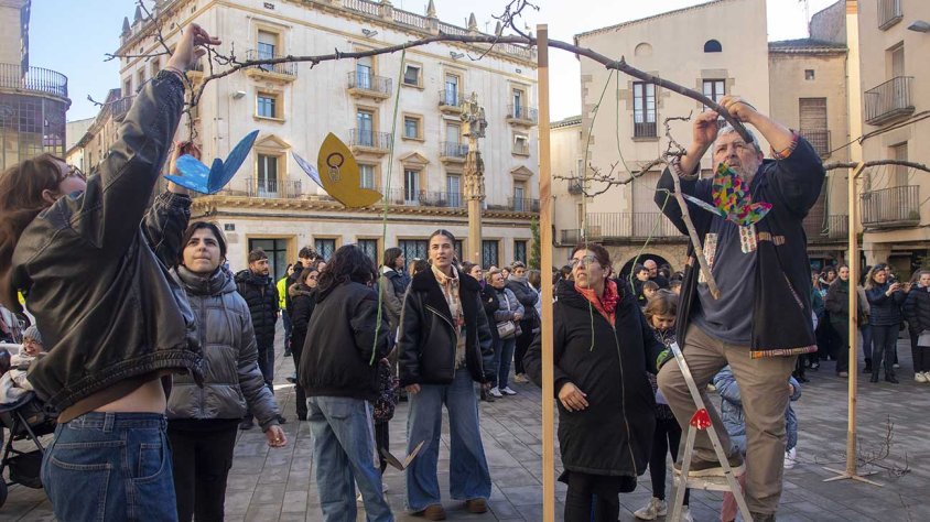 Penjant les papallones a la instal·lació artística ideada per l'Escola d'Art Ondara