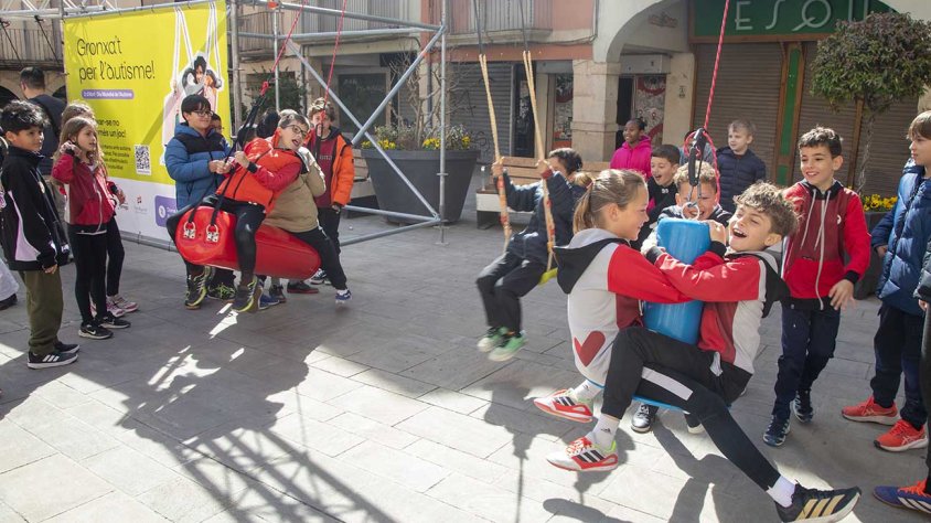 Escolars de la ciutat amb els gronxadors adaptats a la plaça Major