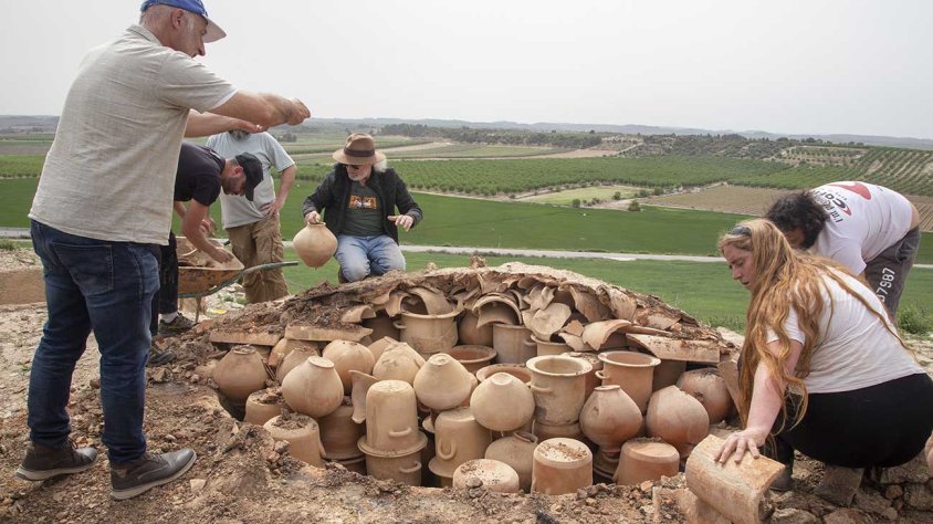 Membres del projecte traient les peces de ceràmica del forn experimental després de la seva cocció